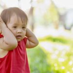 Child covering ears.