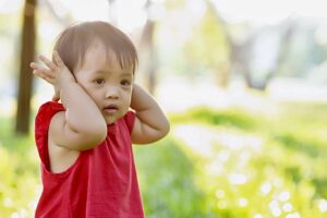 Child covering ears.